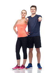 Image showing happy sportive man and woman pointing finger