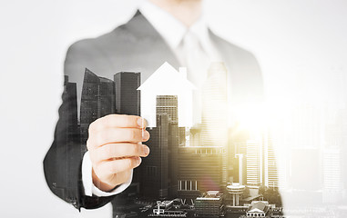 Image showing close up of businessman holding paper house