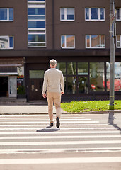 Image showing senior man walking along city crosswalk