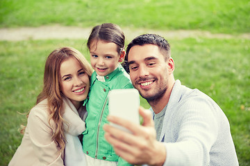 Image showing happy family taking selfie by smartphone outdoors