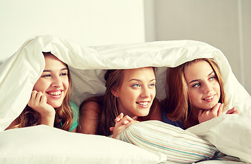 Image showing happy young women in bed at home pajama party