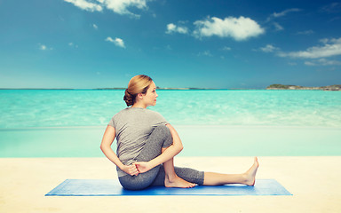 Image showing woman making yoga in twist pose on mat