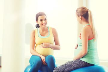 Image showing two happy pregnant women sitting on balls in gym