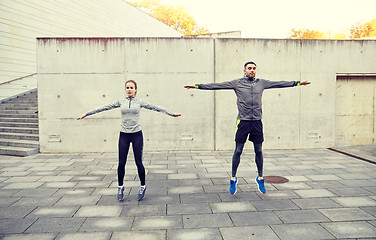 Image showing happy man and woman jumping outdoors