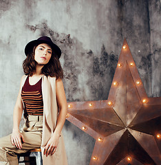Image showing young pretty woman waiting alone in modern loft studio, hipster in hat, fashion musician concept, lifestyle people 