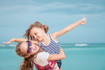 Image showing Sister and brother playing on the beach at the day time.