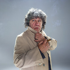 Image showing The senior man with cigar as detective or boss of mafia on gray studio background