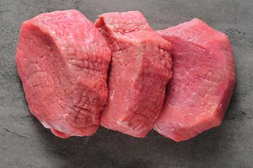 Image showing three piecea of raw beef meat on shale board