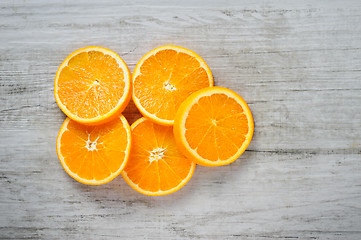 Image showing Slices of fresh oranges on white wood background