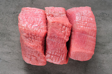 Image showing three piecea of raw beef meat on shale board