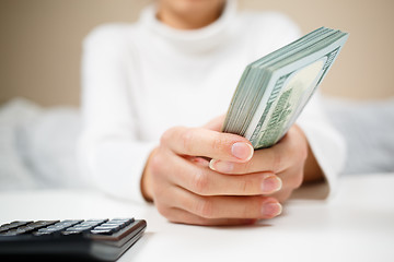 Image showing Woman hand hold cash dollar banknotes. Only hundreds.