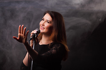 Image showing Singing girl on smoke background