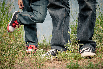 Image showing Father and son playing at the park near lake at the day time.