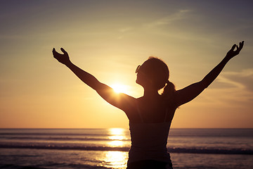 Image showing woman open arms under the sunset at sea