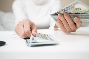 Image showing Close up of woman with calculator counting money