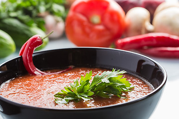 Image showing tomato soup in a black plate. 