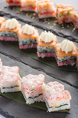 Image showing set of sushi on a slate square plate. 