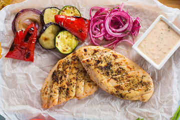 Image showing Grilled chicken breast with fries and salad