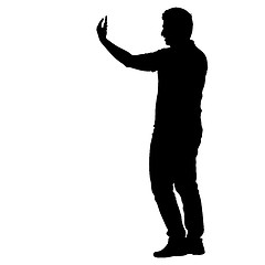 Image showing Silhouettes man taking selfie with smartphone on white background