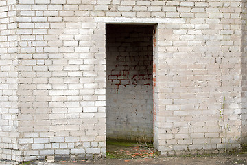 Image showing white cracked brick wall with a doorway