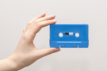 Image showing hand holding blue cassette tape