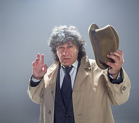 Image showing The senior man as detective or boss of mafia on gray studio background