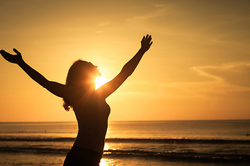 Image showing woman open arms under the sunrise at sea