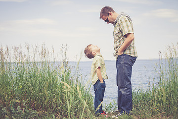 Image showing Father and son playing at the park near lake at the day time.