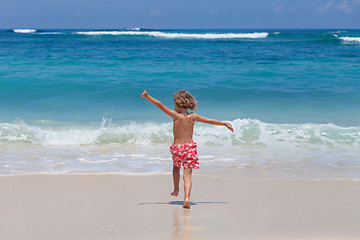 Image showing Happy little boy running on the beach