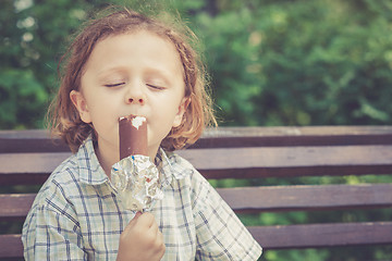 Image showing little boy eating ice cream in the park