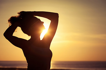 Image showing woman open arms under the sunset at sea