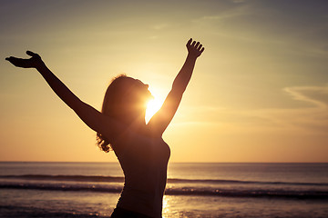 Image showing woman open arms under the sunset at sea