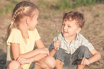 Image showing Two happy children  playing near the tree