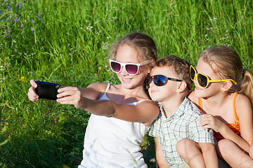 Image showing Three happy children  playing in the park at the day time.