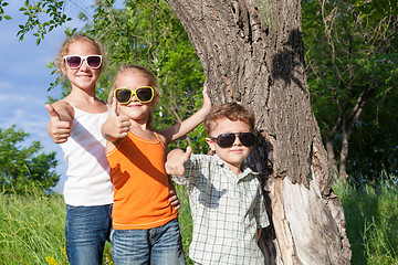 Image showing Three happy children  playing in the park at the day time.