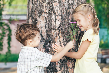 Image showing Two happy children  playing near the tree 