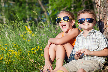 Image showing Two happy children  playing near the tree at the day time.