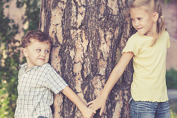 Image showing Two happy children  playing near the tree