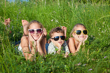 Image showing Three happy children  playing in the park at the day time.