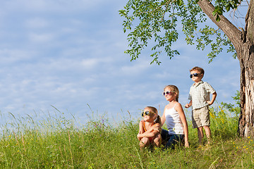 Image showing Three happy children  playing in the park at the day time.