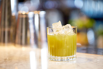 Image showing glass of cocktail with ice cubes at bar