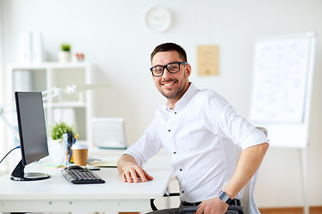 Image showing happy smiling businessman with computer at office