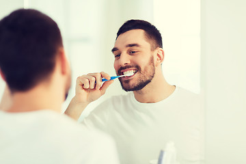 Image showing man with toothbrush cleaning teeth at bathroom