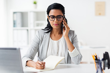 Image showing businesswoman calling on smartphone at office