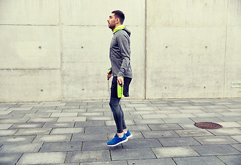 Image showing man exercising with jump-rope outdoors