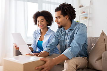 Image showing happy couple with parcel box and paper form home