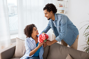 Image showing happy couple with bunch of flowers at home