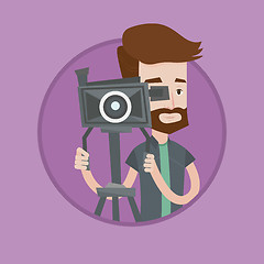 Image showing Cameraman with movie camera on tripod.
