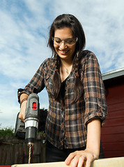 Image showing Craftsperson Woman Uses Power Screwdriver Drilling Wood Project