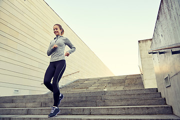 Image showing happy sporty woman running downstairs in city